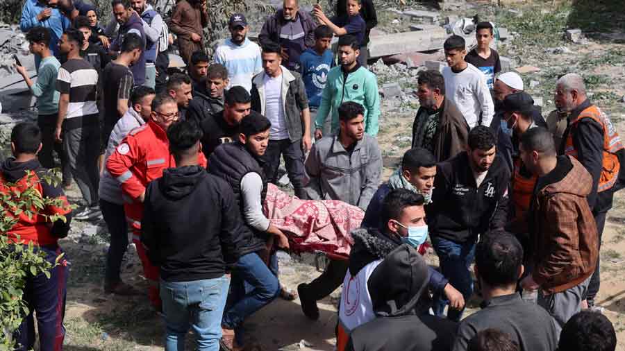 Archivo | Palestinos cargan el cuerpo de una persona muerta en un bombardeo israelí